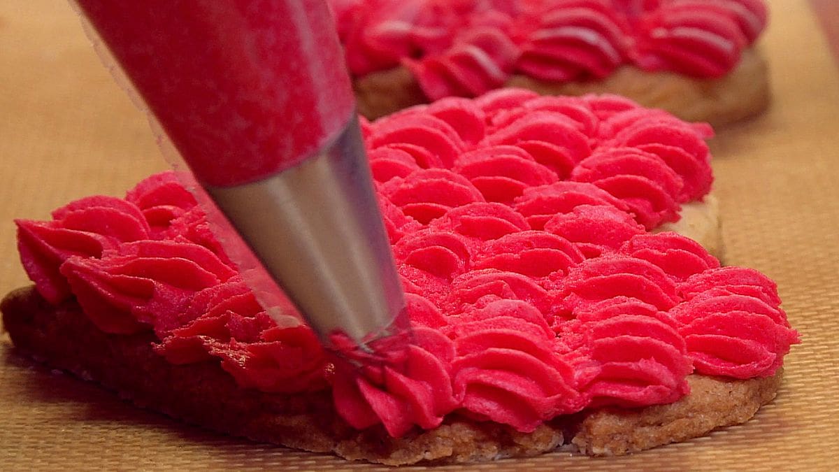 close up of decorating cookies with frosting